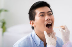 Otolaryngologist checking patient's throat for signs of Strep Throat or Tonsillitis